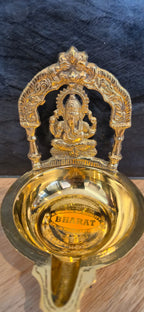 Ganesha diya brass oil lamp on dark background