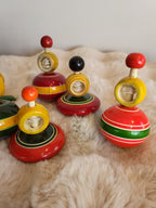 Channapatna wooden spinning tops side view showing domed lacquered body, ring spool and coloured ball top