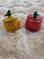 Channapatna wooden trinket boxes in yellow and red with green bird lids on white fur rug
