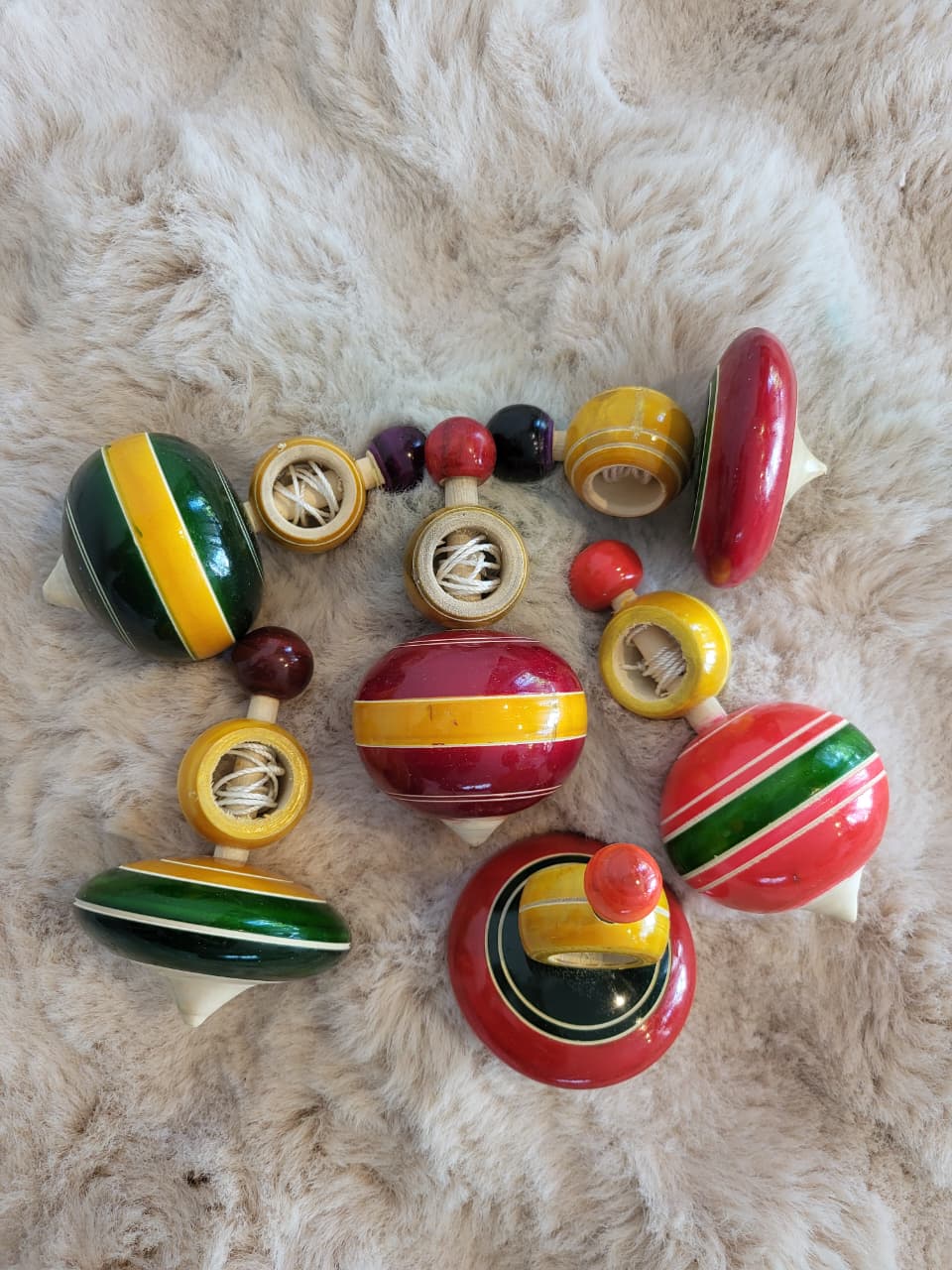 Assortment of Channapatna wooden spinning tops flat lay showing multiple colour combinations