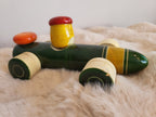 Channapatna wooden toy racing car three-quarter front view showing driver and orange disc detail