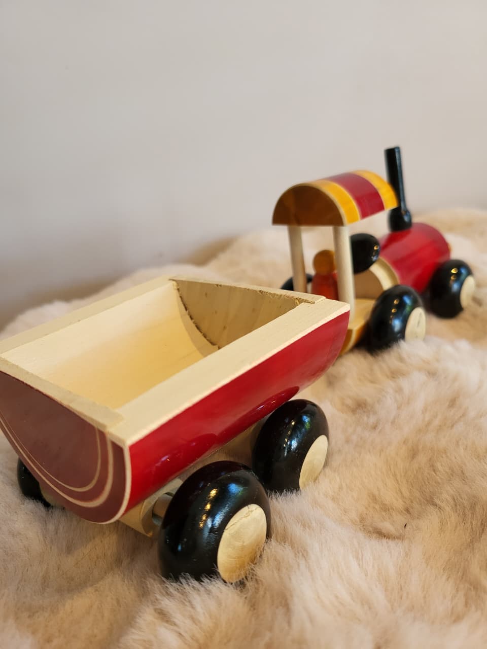 Wooden toy tractor side angle view showing trailer attachment