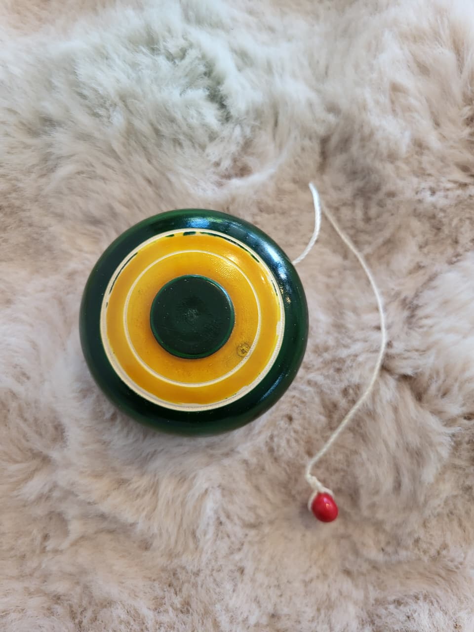 Channapatna wooden yo-yo flat lay side view on fur rug