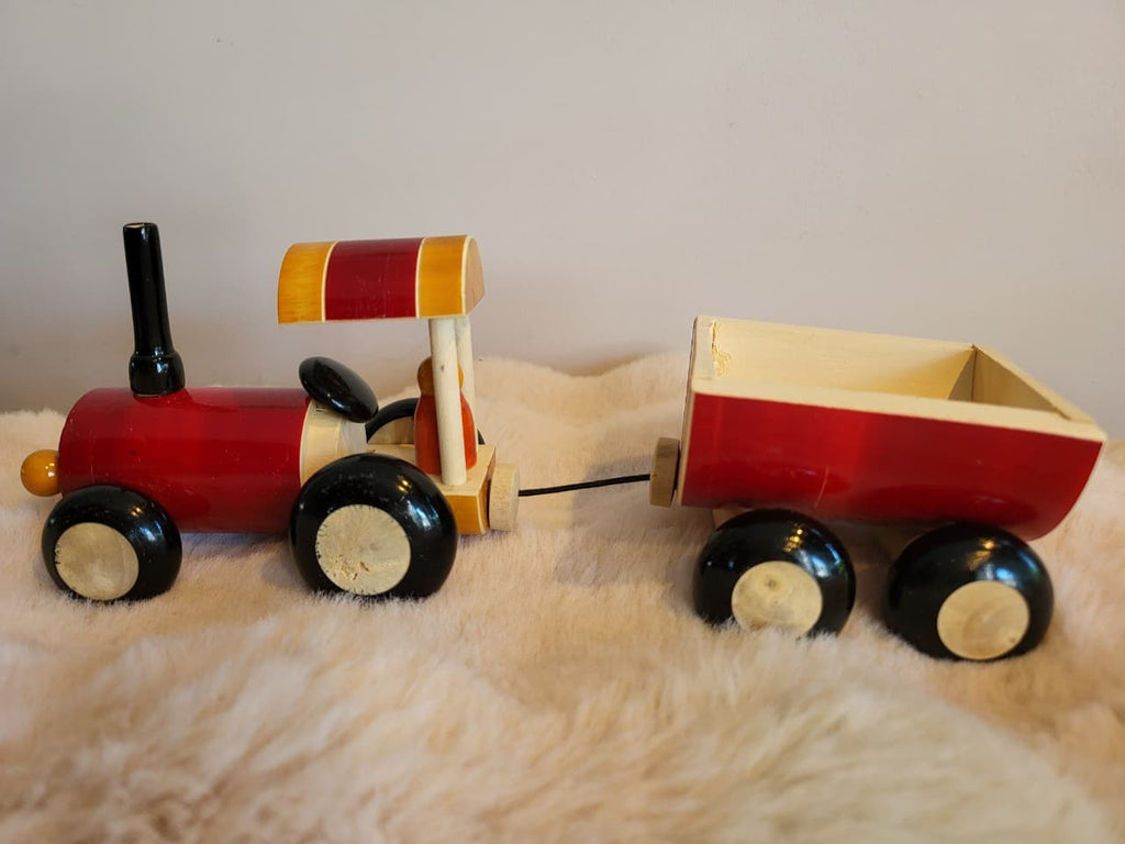 Wooden toy tractor and trailer side view on fur rug