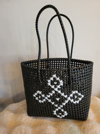 Handwoven black tote bag side angle view showing diamond motif detail