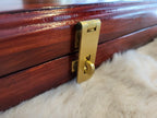 Close-up of brass latch on rosewood Pallanguzhi board