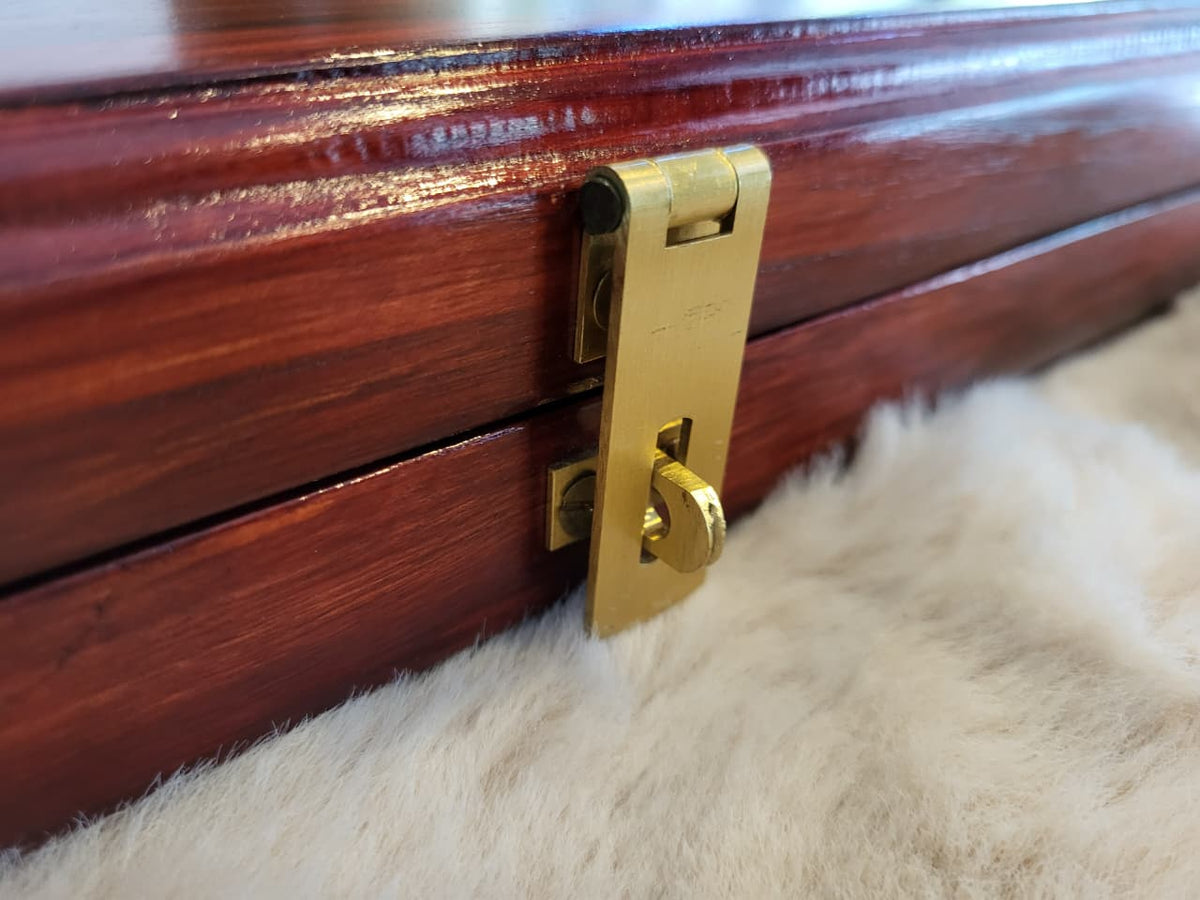 Close-up of brass latch on rosewood Pallanguzhi board
