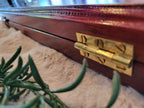 Close-up of brass hinge on rosewood Pallanguzhi board