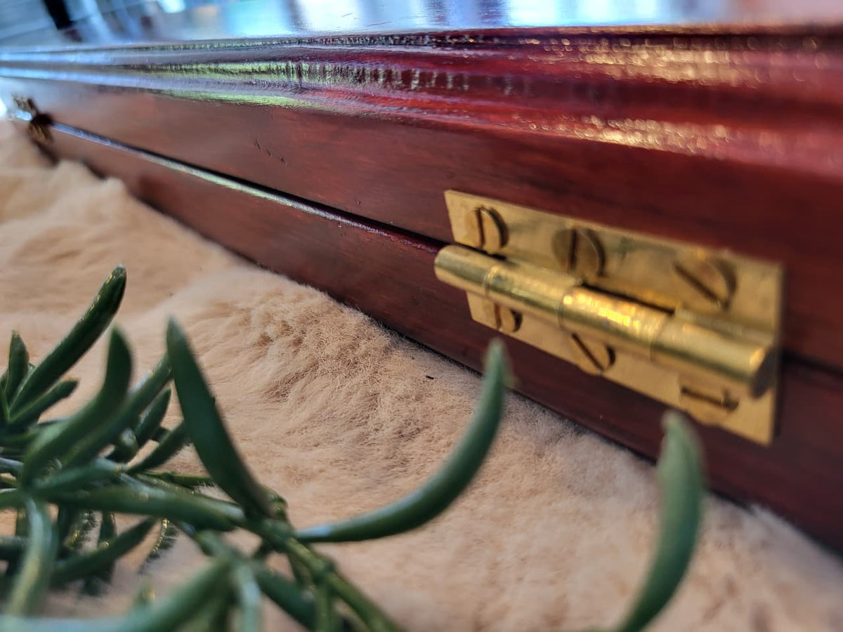 Close-up of brass hinge on rosewood Pallanguzhi board