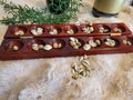 Mancala board open with cowrie shells in pits, vertical view