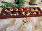 Mancala board open with cowrie shells in pits, vertical view
