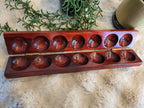Mancala board open showing both rows with cowrie shells