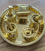 Miniature brass puja thali set with glossy gold finish on wooden surface