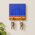 Compact blue key holder with keys on a wall