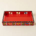Overhead view of red wooden tray with dotted black border