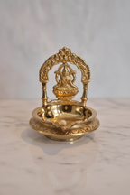 Lakshmi diya on white marble with temple-inspired lighting