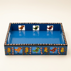 Blue wooden tray showing hand-painted bird motifs and cut-out handles
