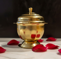 Kumkuma Bharani brass box on white marble with rose petals