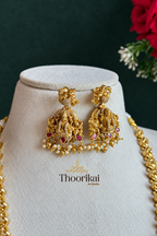 Nakshi gold earrings displayed on a white bust against a dark green background with Thoorikai logo