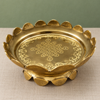 Brass engraved uruli on linen with sage background