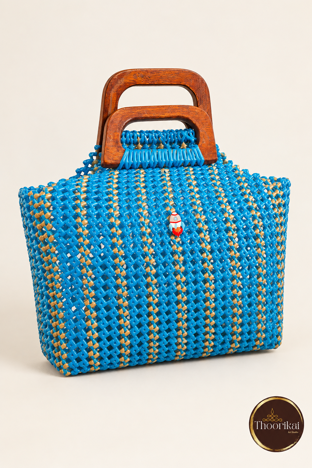 Angled front perspective of blue-gold woven handbag with wooden handles