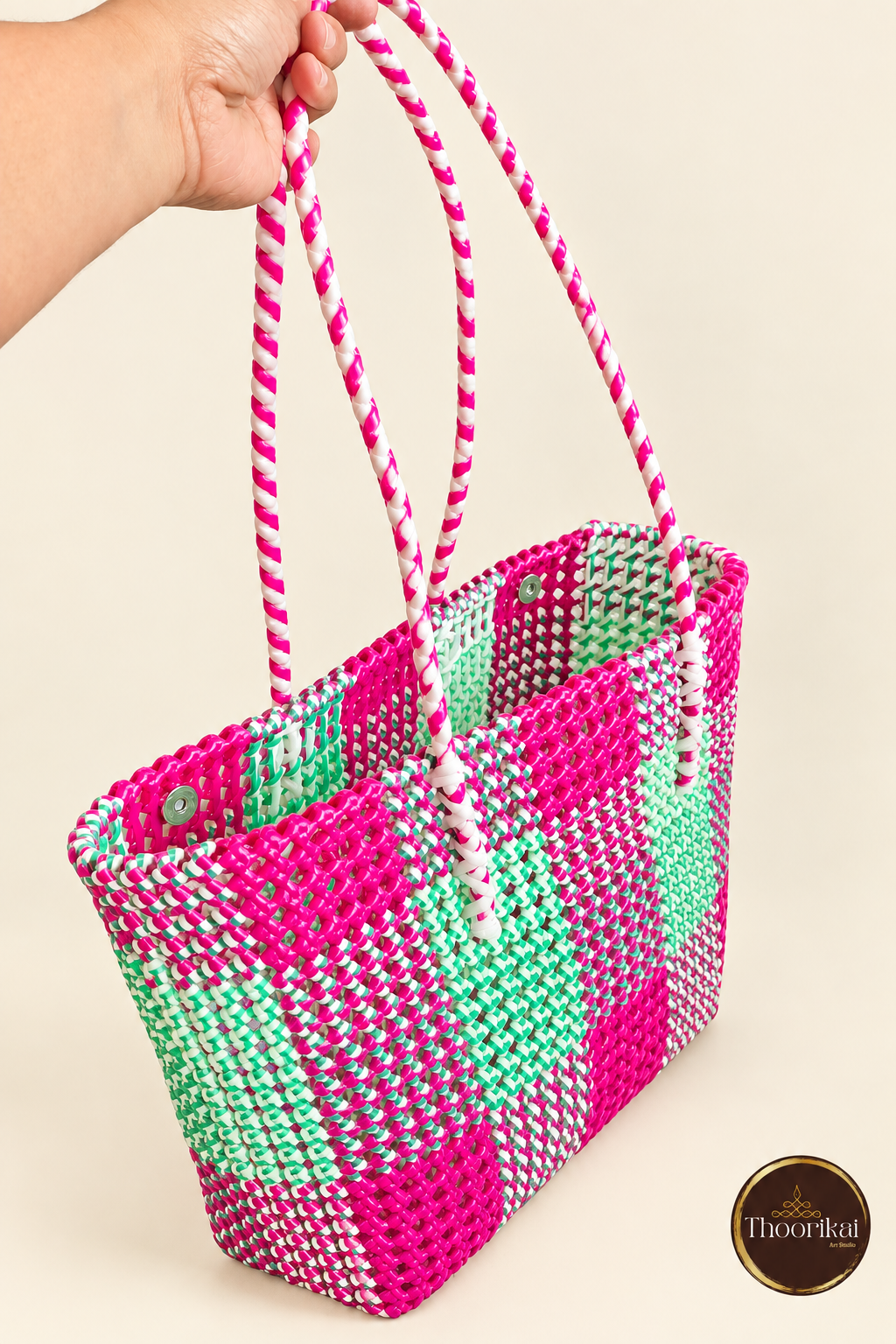 Angled view of Pink-Green Kattam market bag held by its striped handles