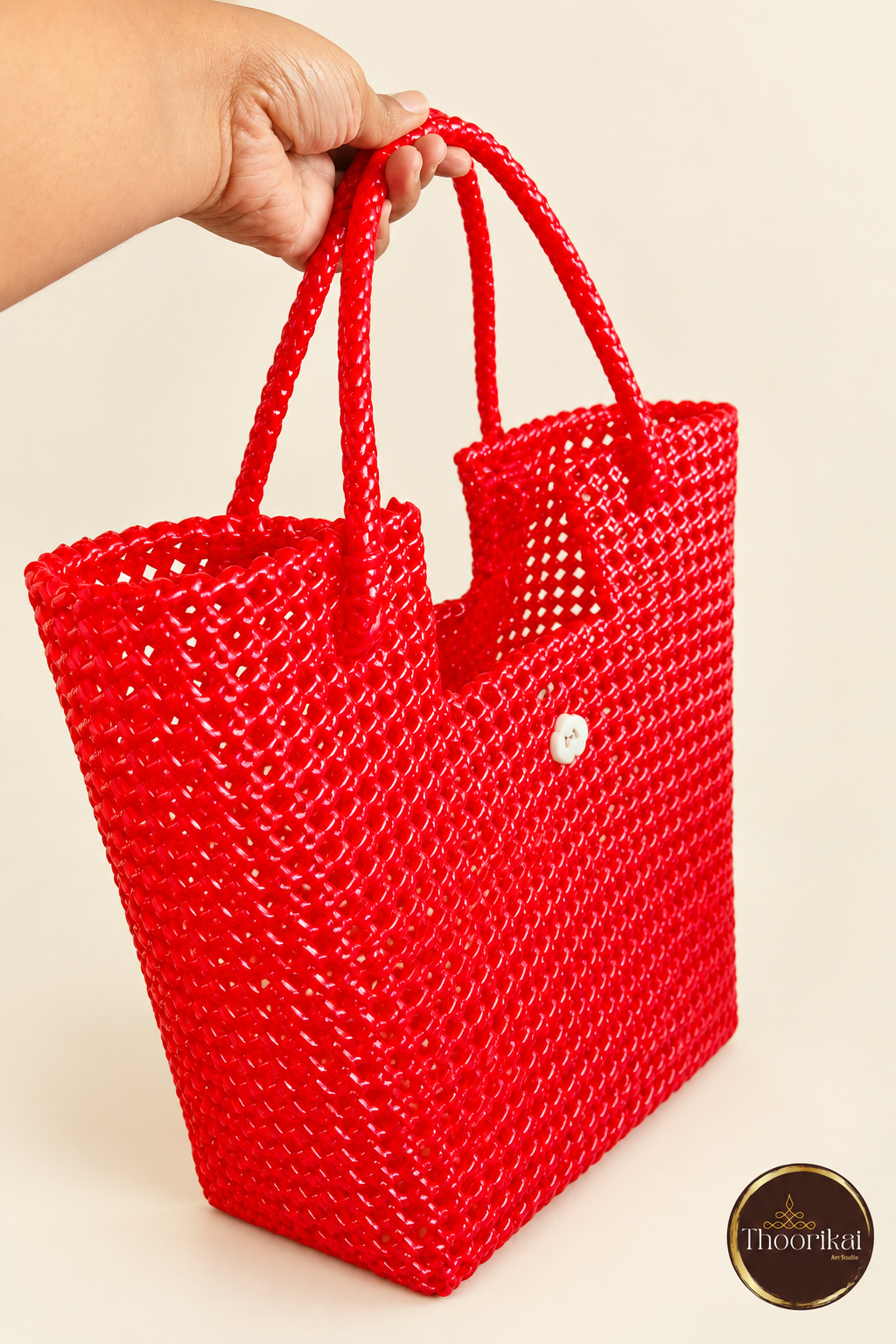 Angled view of red woven tote held by its loop handles