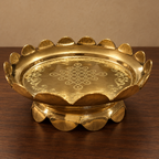 Low-angle view of brass uruli and petal-edged pedestal on walnut