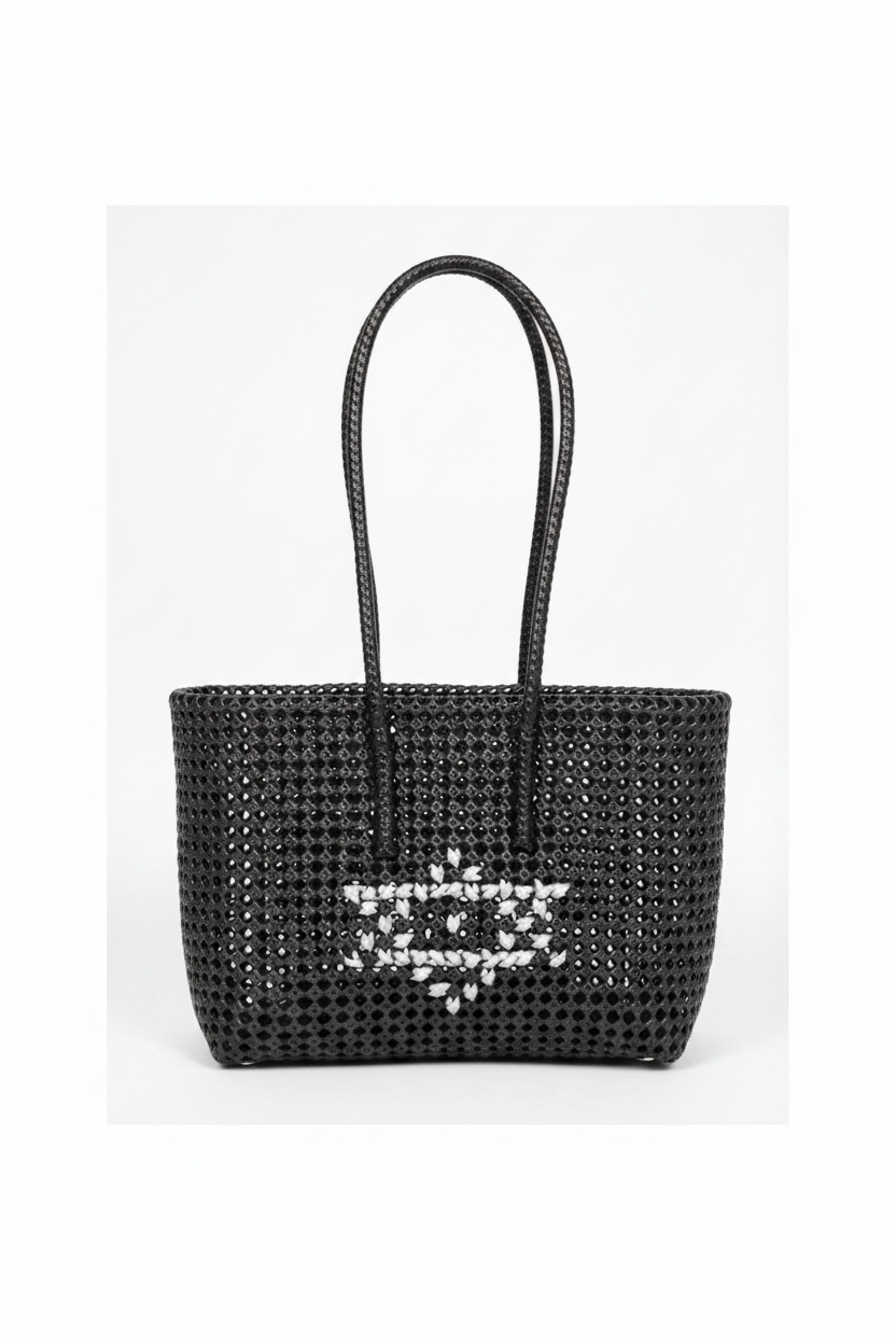 Black woven tote bag with heart motif front view styled product photo