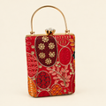 Red embroidered top-handle box bag on an ivory studio background