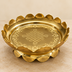 Three-quarter view of brass lotus uruli on pale stone