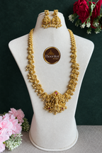 Long Nakshi gold-bead haram and matching earrings on display bust against dark green background