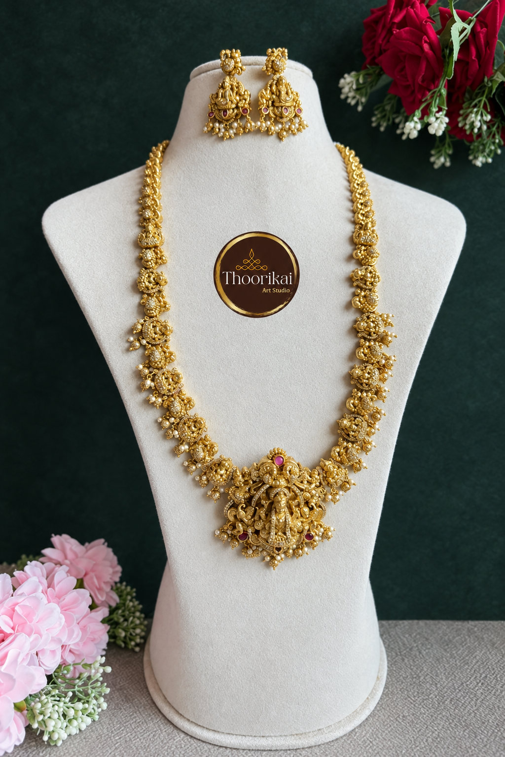 Long Nakshi gold-bead haram and matching earrings on display bust against dark green background