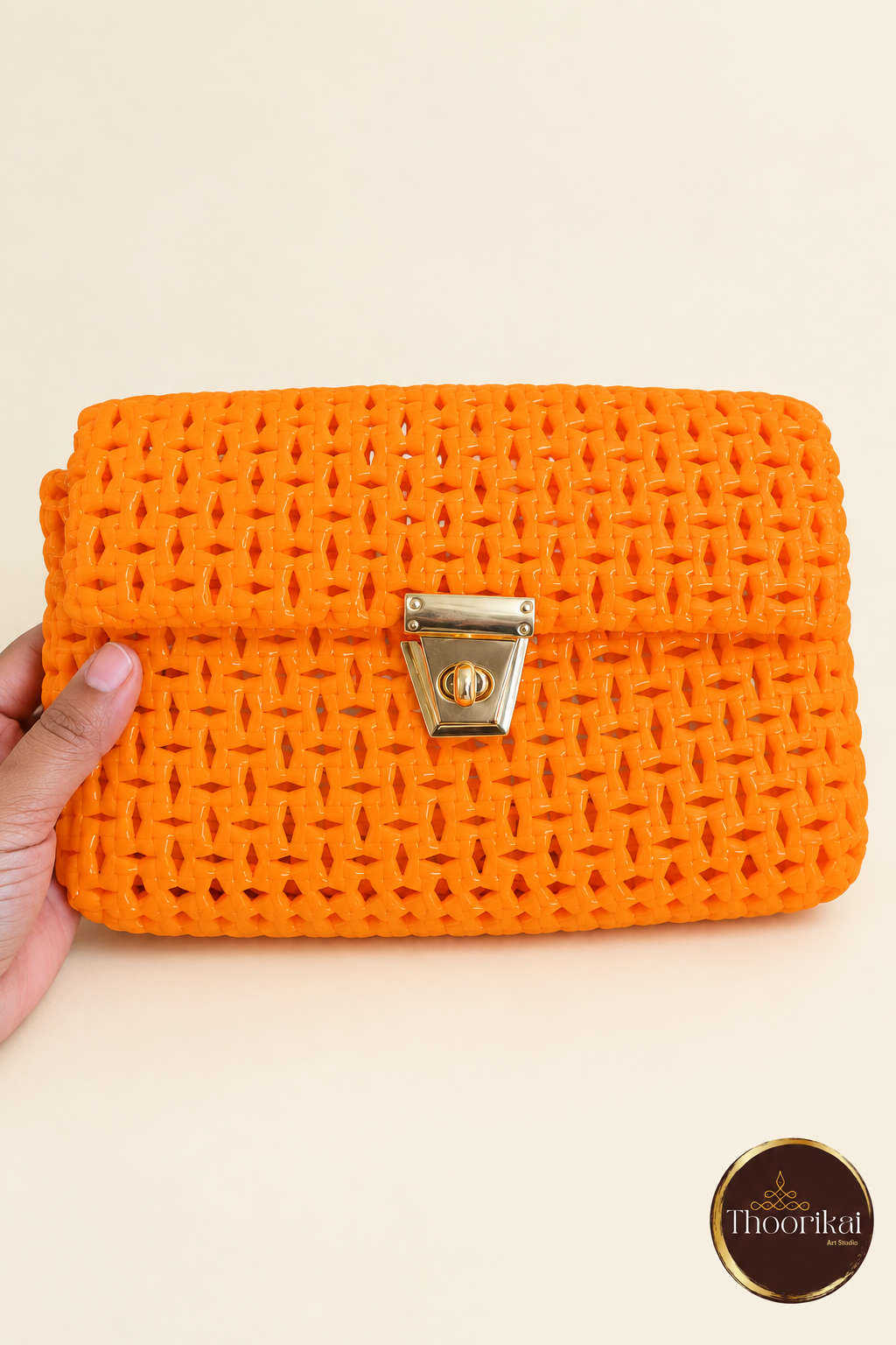 Front view of orange handwoven clutch with gold-tone clasp