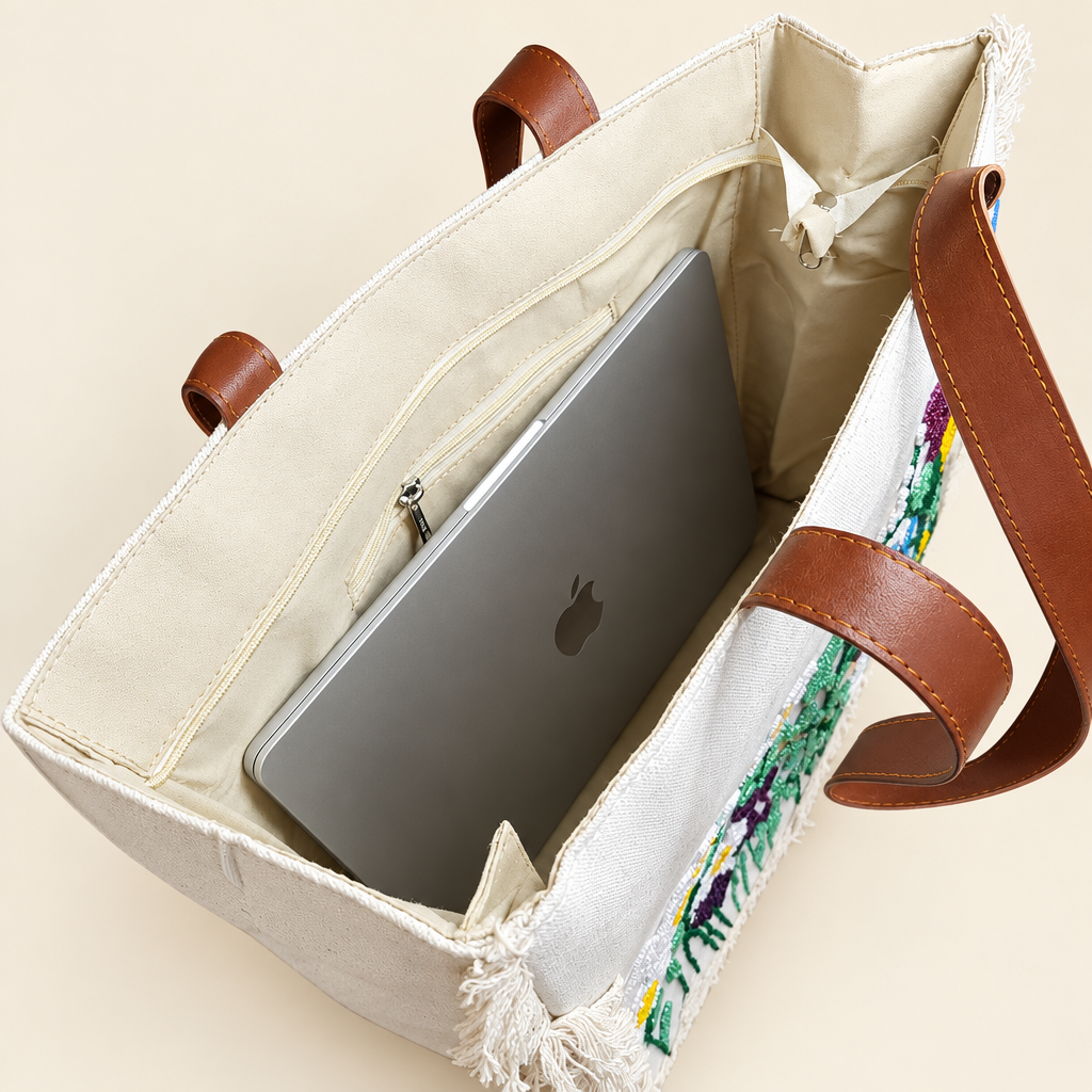 Open embroidered tote showing a MacBook inside, lining and interior zippered pouch; laptop not included